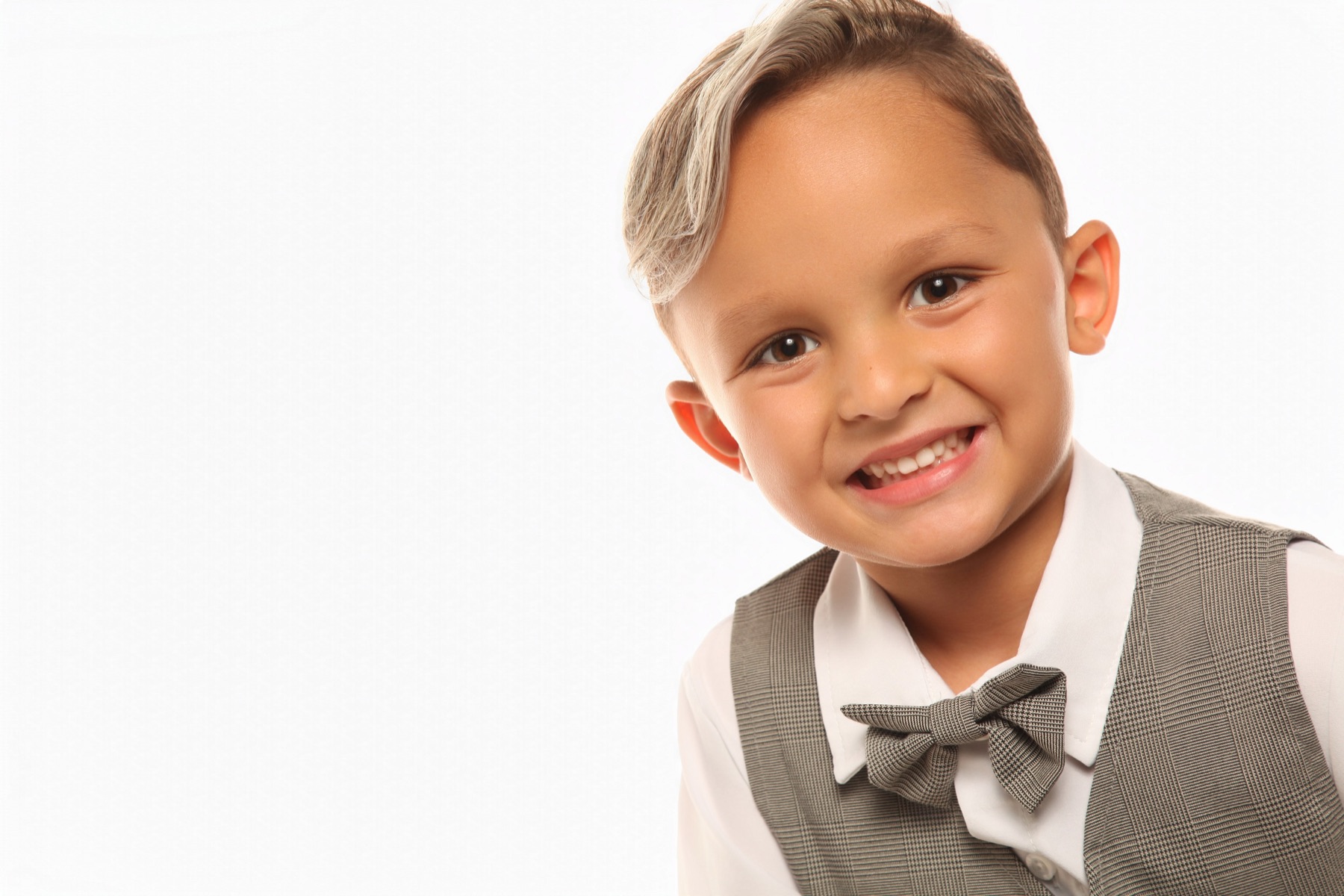 Close-up of Christopher smiling in a gray vest and bow tie
