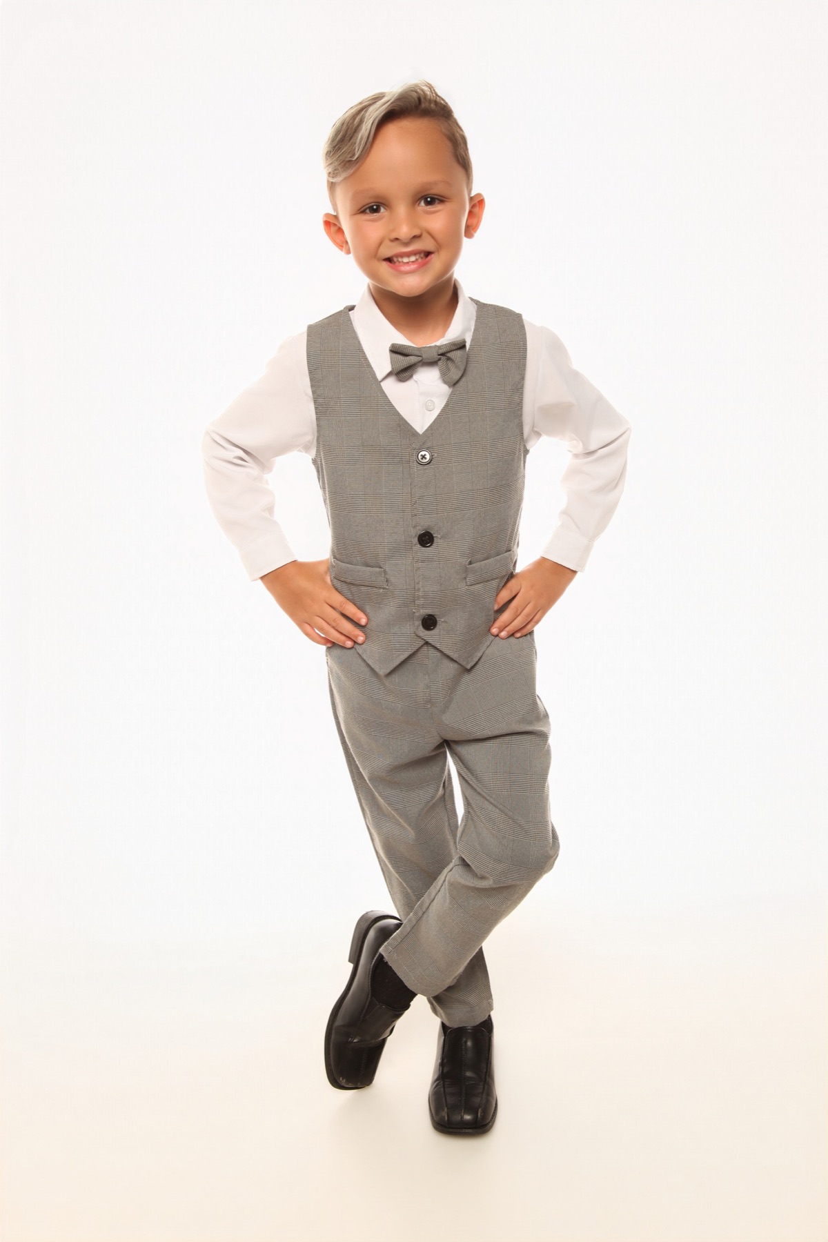 Christopher in his gray vest and bow tie, hands on hips with a big smile