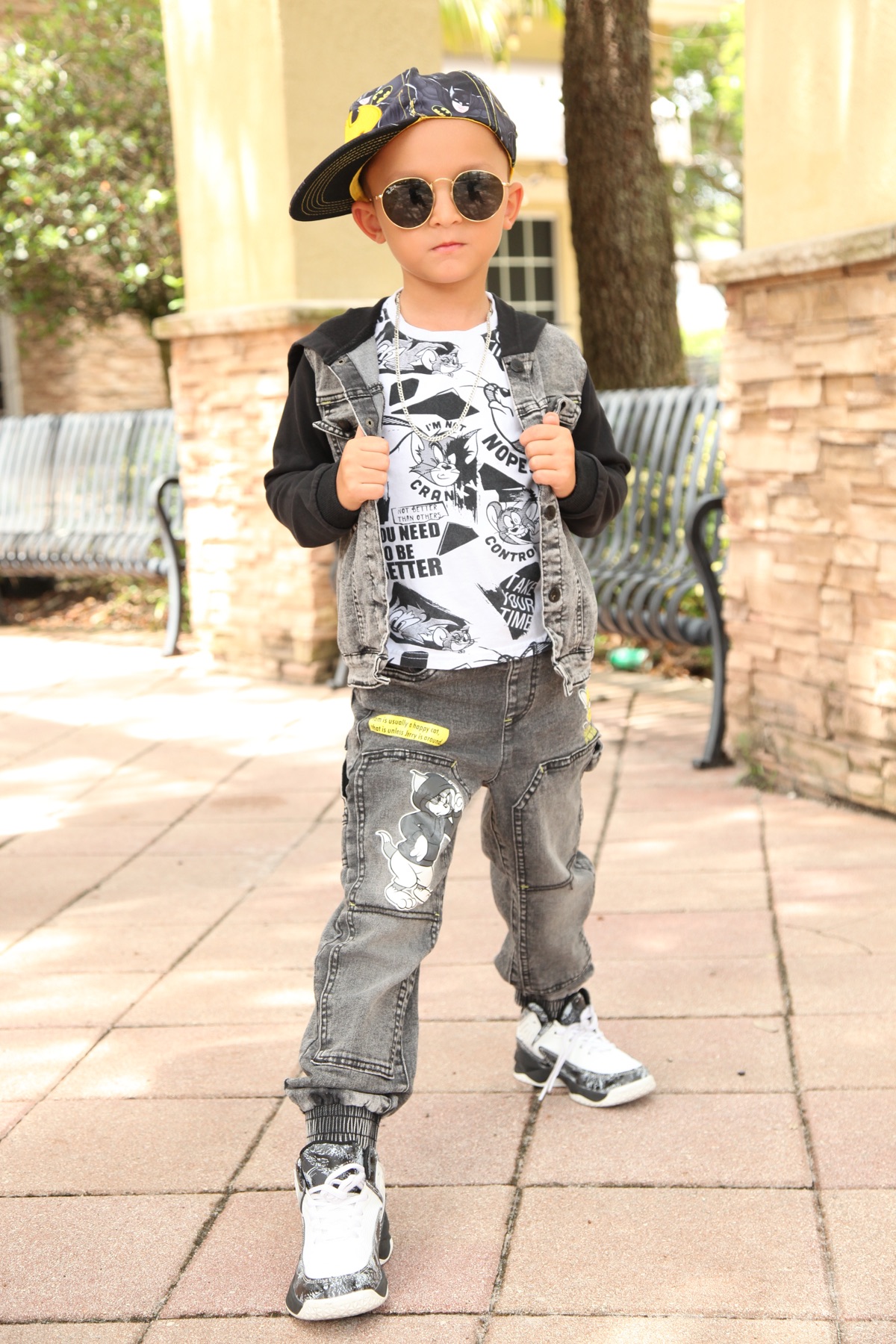 Christopher in sunglasses and Batman cap standing confidently outdoors