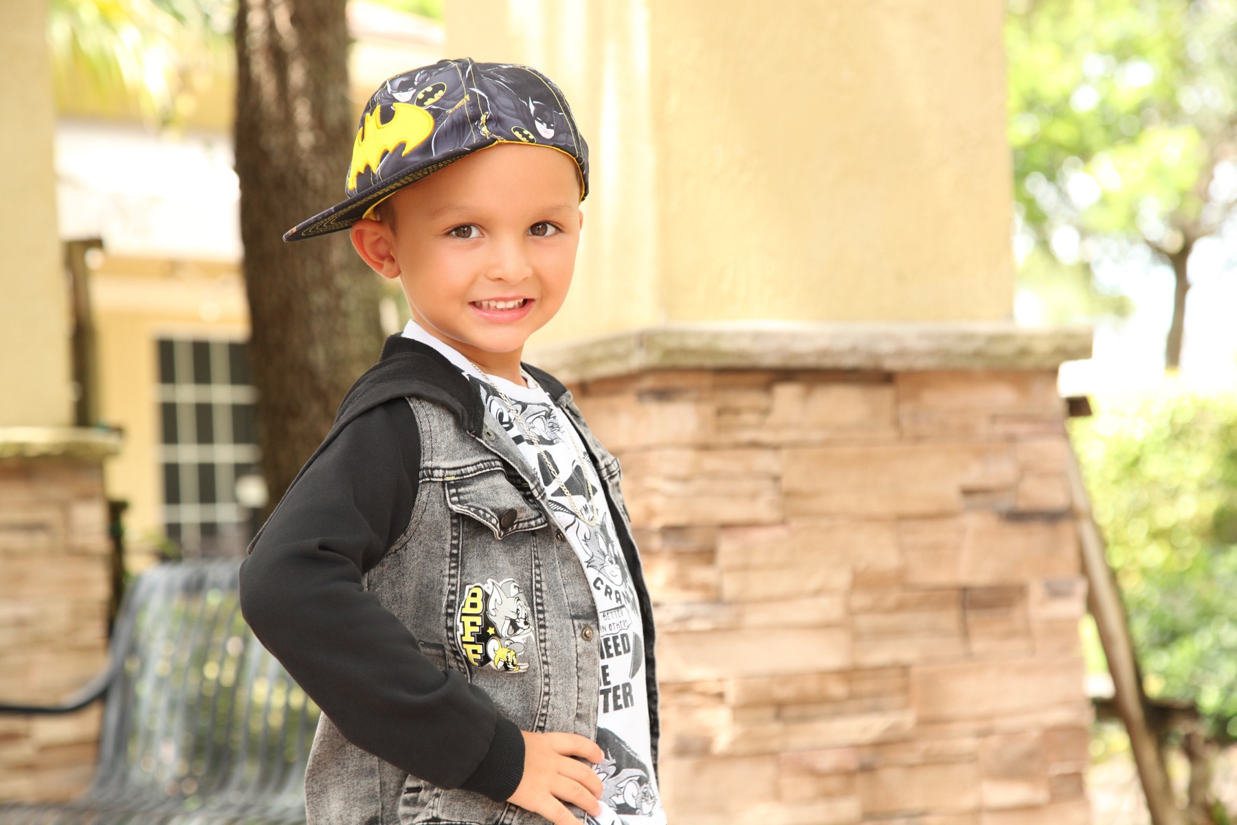 Christopher laughing under his Batman cap on an outdoor shoot